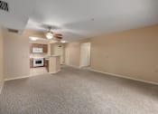 Thumbnail 39 of 50 - A spacious room with a ceiling fan and carpeted floor.