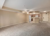 Thumbnail 40 of 50 - Empty room with a ceiling fan and a kitchenette in the background.