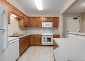 Thumbnail 41 of 50 - A kitchen with white appliances and wooden cabinets.