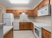 Thumbnail 42 of 50 - A kitchen with white appliances and wooden cabinets.
