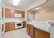 Thumbnail 43 of 50 - A kitchen with brown cabinets and white appliances.