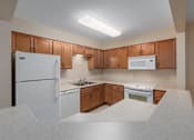 Thumbnail 44 of 50 - A kitchen with white appliances and wooden cabinets.
