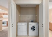 Thumbnail 50 of 50 - A white dryer and washer are in a small laundry room.