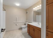 Thumbnail 47 of 50 - A bathroom with a toilet, sink, and mirror.