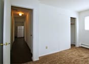 Thumbnail 5 of 7 - a bedroom with a carpeted floor and a door to a hallway and a closet