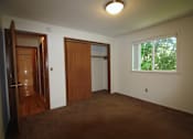 Thumbnail 5 of 6 - an empty living room with a door to a closet and a window