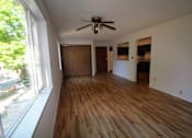 Thumbnail 4 of 6 - an empty living room with wooden floors and a ceiling fan