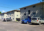 Thumbnail 3 of 7 - a parking lot filled with cars in front of buildings
