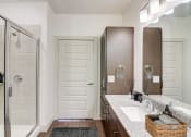 Thumbnail 12 of 44 - a bathroom with a shower and a sink and a mirror
