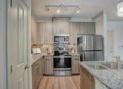 Thumbnail 6 of 52 - a kitchen with granite counter tops and stainless steel appliances