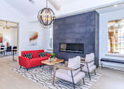 Thumbnail 28 of 41 - A modern living room with a red couch and a fireplace.