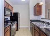 Thumbnail 7 of 41 - A kitchen with black appliances and brown cabinets.