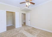 Thumbnail 12 of 41 - A room with a ceiling fan and carpeted floor.