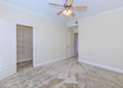 Thumbnail 21 of 41 - A room with a ceiling fan and carpeted floor.