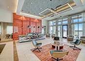 Thumbnail 15 of 30 - A modern living room with a red accent wall and a variety of seating options.