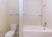 Thumbnail 26 of 41 - A white toilet and bathtub in a bathroom.