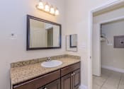 Thumbnail 23 of 41 - A bathroom with a sink, mirror, and light fixture.