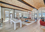 Thumbnail 22 of 30 - A modern living room with a wooden ceiling and a white coffee table.