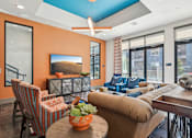 Thumbnail 32 of 49 - A living room with orange walls and furniture.