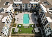 Thumbnail 37 of 44 - an aerial view of a building with a pool and lawn