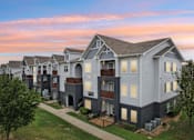 Thumbnail 35 of 70 - A row of modern townhouses with a sunset sky in the background.