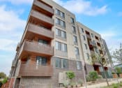Thumbnail 45 of 50 - an apartment building with two balconies and a blue sky