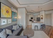 Thumbnail 14 of 52 - a living room with a couch and a kitchen with a bar