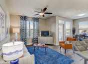 Thumbnail 1 of 50 - a living room with a blue rug and a ceiling fan