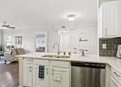 Thumbnail 3 of 70 - A kitchen with a stainless steel dishwasher and a white countertop.