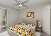 Thumbnail 8 of 13 - A bedroom with a bed, a ceiling fan, and a painting on the wall.