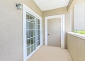 Thumbnail 15 of 41 - A hallway with a glass door and a white door.