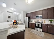 Thumbnail 6 of 40 - A kitchen with brown cabinets and a white counter.