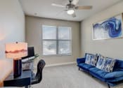 Thumbnail 7 of 50 - a living room with a blue couch and a ceiling fan