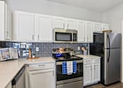 Thumbnail 1 of 70 - A kitchen with white cabinets and a black stove top.