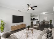 Thumbnail 21 of 70 - A living room with a grey couch, a coffee table, a flat screen TV, and a ceiling fan.