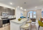 Thumbnail 14 of 44 - an open kitchen and living room with a marble counter top
