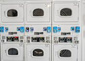 Thumbnail 17 of 33 - A row of washing machines with the front loading doors open.