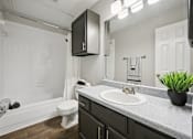 Thumbnail 16 of 45 - A bathroom with a white tub, toilet, and sink.