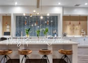 Thumbnail 4 of 17 - a kitchen with a white counter top and wooden stools