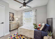 Thumbnail 6 of 18 - a bedroom with a bed and a ceiling fan