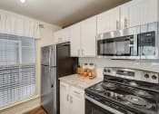 Thumbnail 7 of 44 - an updated kitchen with stainless steel appliances and white cabinets