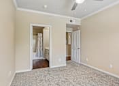 Thumbnail 8 of 32 - A room with a carpeted floor and a ceiling fan.