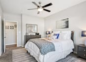 Thumbnail 9 of 70 - A bedroom with a large bed and a ceiling fan.