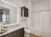 Thumbnail 17 of 37 - a bathroom with a shower sink and toilet and a mirror