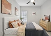 Thumbnail 10 of 45 - A bedroom with a bed, dresser, and artwork on the walls.