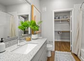 Thumbnail 8 of 29 - A bathroom with a white sink and a white toilet.