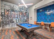 Thumbnail 33 of 49 - A pool table in a room with a graffiti wall.