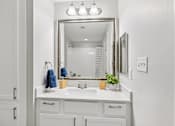 Thumbnail 17 of 70 - A bathroom with a white sink and a mirror above it.