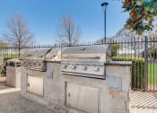 Thumbnail 22 of 42 - an outdoor kitchen with two gas grills and two trash cans