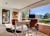 Thumbnail 26 of 42 - a home office with a large window and a table with chairs